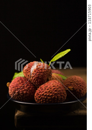 Small ripe tropical lychee berries on a black plate in a minimalist style, low key Small ripe tropical lychee berries on a black plate in a minimalist style, low key 118715903