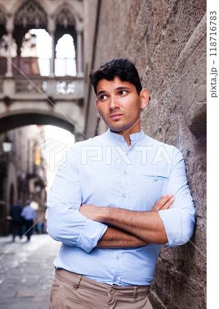 Young European guy in blue shirt walking around city Young European guy in blue shirt walking around city 118716783