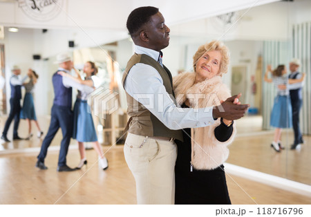 Man and mature woman learning to dance classical ballroom dance Man and mature woman learning to dance classical ballroom dance 118716796