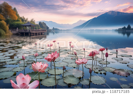Chinese gazebo in the distance on a lake with blooming pink lotuses, mountains in the background 118717185