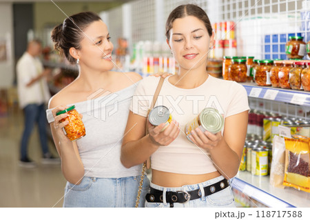 Cheerful young women selecting Asian pickles in supermarket Cheerful young women selecting Asian pickles in supermarket 118717588