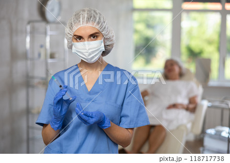 Portrait of young female doctor in scrub and surgical cap. 118717738