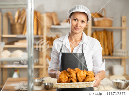 bakery worker shows off a variety of different crescent-shaped buns 118717875
