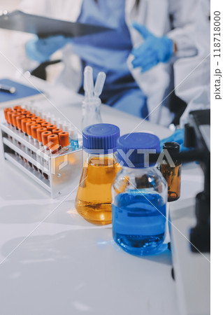 Scientist using microscope in laboratory. Close-up of a researcher's hands adjusting a modern microscope in a lab setting. Science concept 118718000