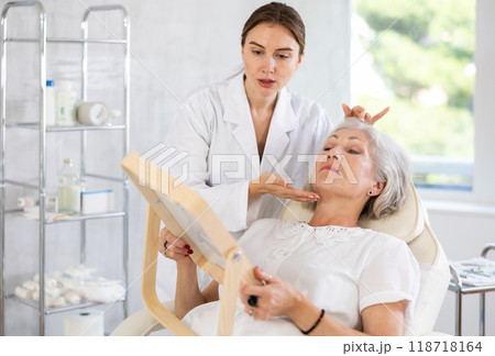 Cosmetologist with gloves preparing patient to skin care procedure in spa salon. Cosmetologist with gloves preparing patient to skin care procedure in spa salon. 118718164