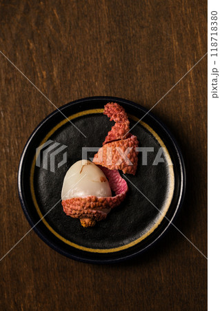 Small ripe tropical lychee berries on a black plate 118718380