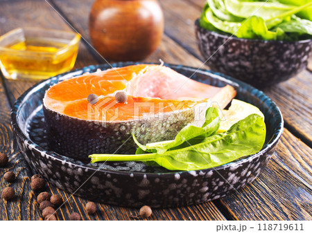 Fresh salmon fillets on dark wooden background with spices Fresh salmon fillets on dark wooden background with spices 118719611
