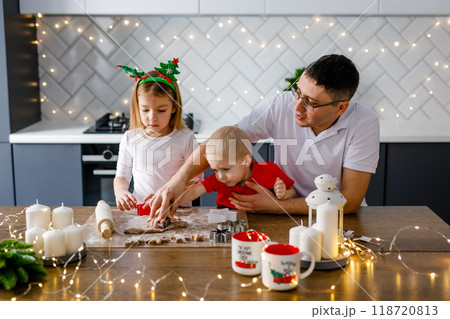 Happy family father and two kids making Christmas cookies together in kitchen at home Happy family father and two kids making Christmas cookies together in kitchen at home 118720813