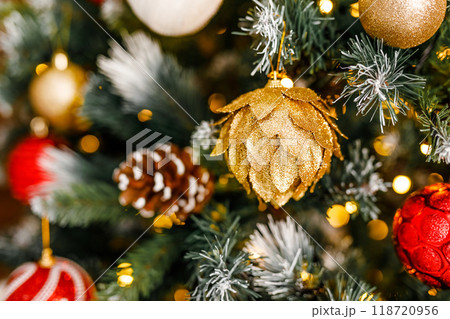 A close-up of a pinecone and a ball with a snowflake on a branch of a Christmas fir. A close-up of a pinecone and a ball with a snowflake on a branch of a Christmas fir. 118720956