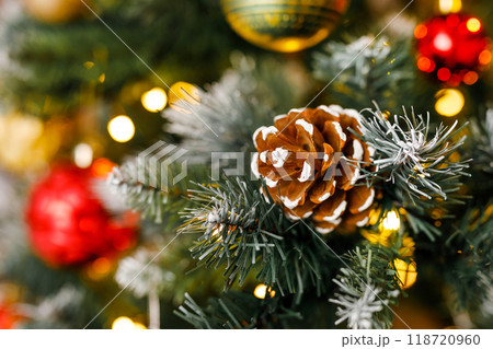 A close-up of a pinecone and a ball with a snowflake on a branch of a Christmas fir. A close-up of a pinecone and a ball with a snowflake on a branch of a Christmas fir. 118720960