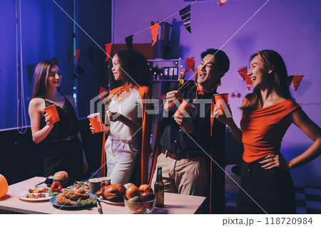 Joyful office Halloween party with coworkers in costumes, celebrating with drinks and laughter, fostering teamwork and festive spirit 118720984