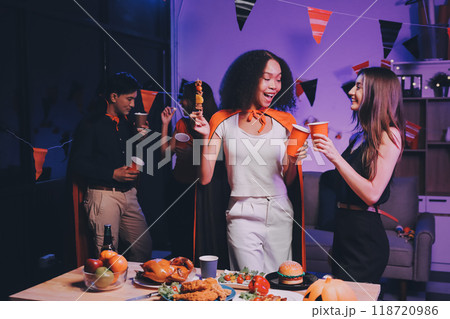 Joyful office Halloween party with coworkers in costumes, celebrating with drinks and laughter, fostering teamwork and festive spirit 118720986