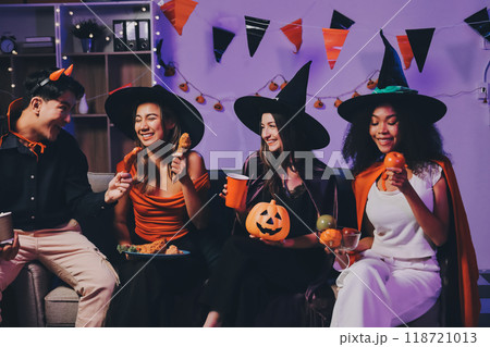 Joyful office Halloween party with coworkers in costumes, celebrating with drinks and laughter, fostering teamwork and festive spirit 118721013