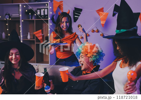Joyful office Halloween party with coworkers in costumes, celebrating with drinks and laughter, fostering teamwork and festive spirit 118721018