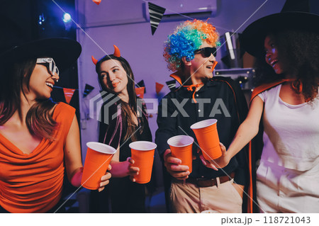 Joyful office Halloween party with coworkers in costumes, celebrating with drinks and laughter, fostering teamwork and festive spirit Joyful office Halloween party with coworkers in costumes, celebrating with drinks and laughter, fostering teamwork and festive spirit 118721043