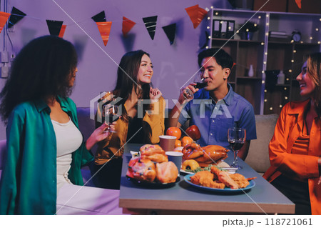 Joyful office Halloween party with coworkers in costumes, celebrating with drinks and laughter, fostering teamwork and festive spirit 118721061