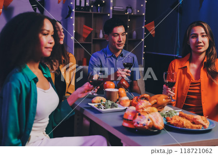 Joyful office Halloween party with coworkers in costumes, celebrating with drinks and laughter, fostering teamwork and festive spirit 118721062