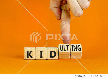 Kid or kidulting symbol. Concept words Kid or Kidulting on wooden cubes. Beautiful orange table orange background. Psychologist hand. Healthy lifestyle and kid or kidulting concept. Copy space. 118721808