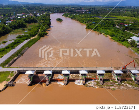 Aerial view of the dam's floodgates with rapid flow of water in the rainy season. Dam water release, dam overcapacity after heavy rain. Aerial view of the dam's floodgates with rapid flow of water in the rainy season. Dam water release, dam overcapacity after heavy rain. 118722171