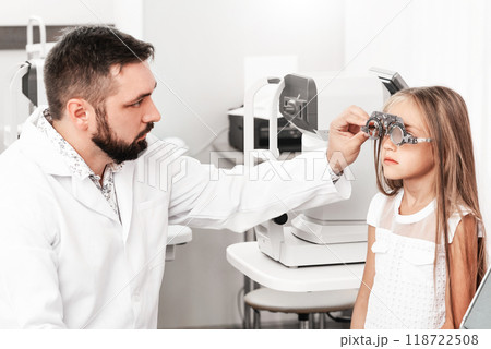 Cute little girl visiting ophthalmologist to check vision 118722508