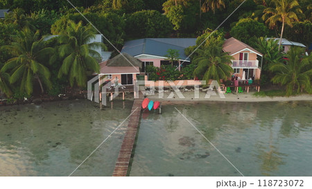 Aerial view of colorful bungalows houses on coast of Bora Bora island with kayaks and boats waiting on the dock pier. Popular tourist destination. Remote exotic summer travel. Drone zoom out panorama Aerial view of colorful bungalows houses on coast of Bora Bora island with kayaks and boats waiting on the dock pier. Popular tourist destination. Remote exotic summer travel. Drone zoom out panorama 118723072