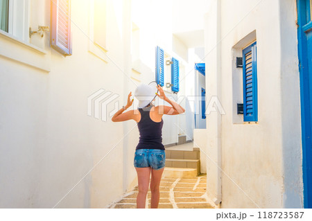Young girl in white hat w on a typical Mykonos street, back view 118723587