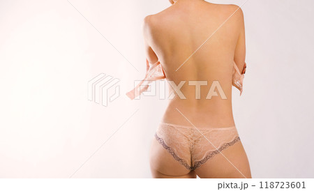 White slim woman with her bra unbuckled, wearing nice peachy underpants, backshot 118723601