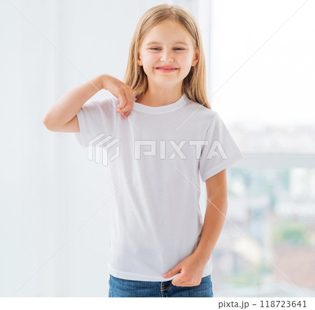 Smiling little girl showing her brand new white t-shirt Smiling little girl showing her brand new white t-shirt 118723641