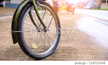 Flat tire wheel of bicycle parking on concrete sidewalk beside a road, need to be repaired, the moment of stillness and an unexpected pause in a journey. Flat tire wheel of bicycle parking on concrete sidewalk beside a road, need to be repaired, the moment of stillness and an unexpected pause in a journey. 118725548