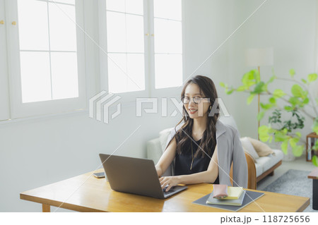 リビングでテレワークをする若い女性 リビングでテレワークをする若い女性 118725656