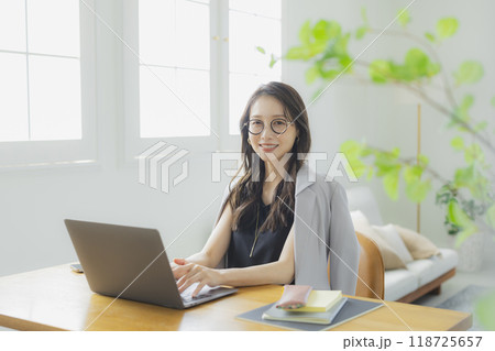 リビングでテレワークをする若い女性 リビングでテレワークをする若い女性 118725657