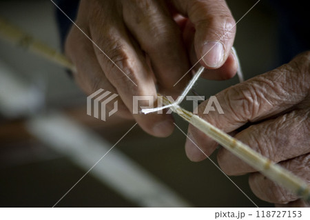 着物を作るための糸をくくる職人の手元 118727153
