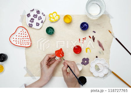 A woman paints clay products. Hobby clay modeling A woman paints clay products. Hobby clay modeling 118727765