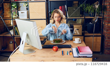Worker handles lunch during meeting. It's essential to set boundaries for meal times, especially to maintain professionalism during online meetings. 118729416