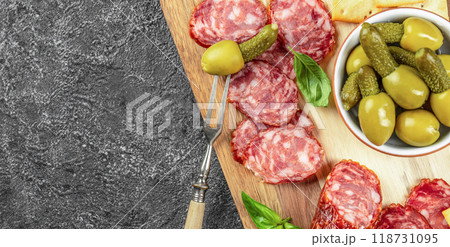 Antipasto board with salami and olives on stone background. place for text, top view 118731095