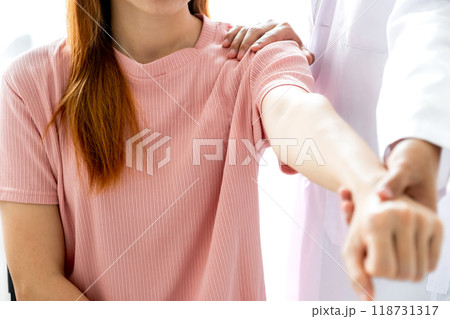 Female doctor hand rehab physical therapy by extending the pain shoulder of a patient. treatment with stretch exercises Female doctor hand rehab physical therapy by extending the pain shoulder of a patient. treatment with stretch exercises 118731317