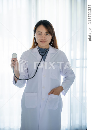 Doctor hand holding stethoscope in front of her with a white background healthcare concept 118731325