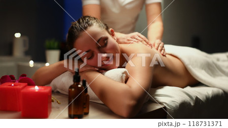 Young woman enjoying being massaged by professional masseuse master 118731371