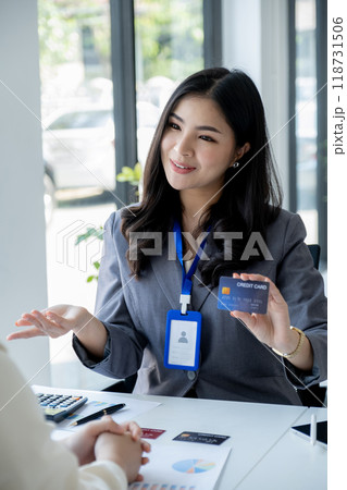 Employees present with mock up credit card payments to business customers. Ready to provide discounts and life insurance 118731506