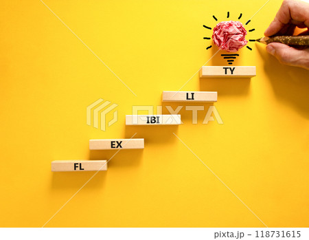 Flexibility symbol. Concept word Flexibility on beautiful wooden blocks. Light bulb icon. Businessman hand with pen. Beautiful yellow background. Business flexibility concept. Copy space. 118731615