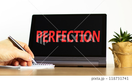 Perfection symbol. Concept word Perfection on beautiful black tablet. Beautiful wooden table white background. Businessman hand with pen. Business perfection concept. Copy space. 118731741