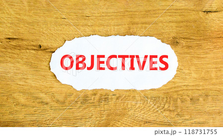 Objectives symbol. Concept word Objectives on beautiful white paper. Beautiful wooden wall background. Business objectives concept. Copy space. 118731755