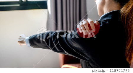 A successful businesswoman feeling shoulder pain and stretching herself after working hard on computer laptop for a long time on sofa in the home office, Office syndrome concept A successful businesswoman feeling shoulder pain and stretching herself after working hard on computer laptop for a long time on sofa in the home office, Office syndrome concept 118731775