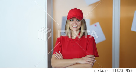 Happy blonde lady courier in red shirt and cap uniform Happy blonde lady courier in red shirt and cap uniform 118731953