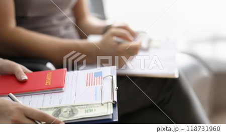 Person sitting in line with visa application forms to get access to enter country Person sitting in line with visa application forms to get access to enter country 118731960