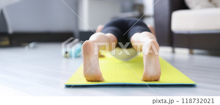 Person barefoot feet on mat performing exercise in morning for health Person barefoot feet on mat performing exercise in morning for health 118732021