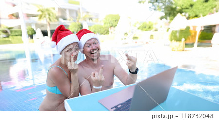 Man and woman in santa claus hats show fucking gesture into monitor Man and woman in santa claus hats show fucking gesture into monitor 118732048