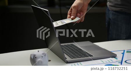 Man invest money through computer screen, put banknote to online bank 118732251