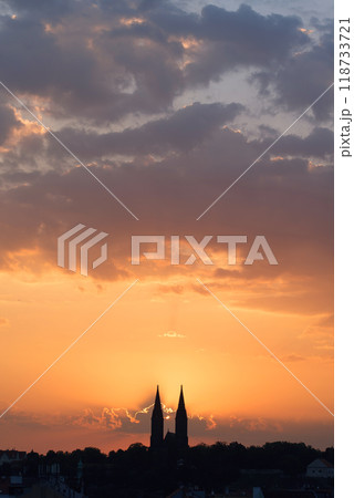 Morning sun rising among two church towers. Beautiful cozy sunrise over the city. Morning sun rising among two church towers. Beautiful cozy sunrise over the city. 118733721