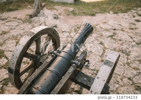Cannon on a carriage located on a white stone pedestal near the arsenal building in Mirow Castle. Sites of Poland. Architecture of World Tourism. 118734233